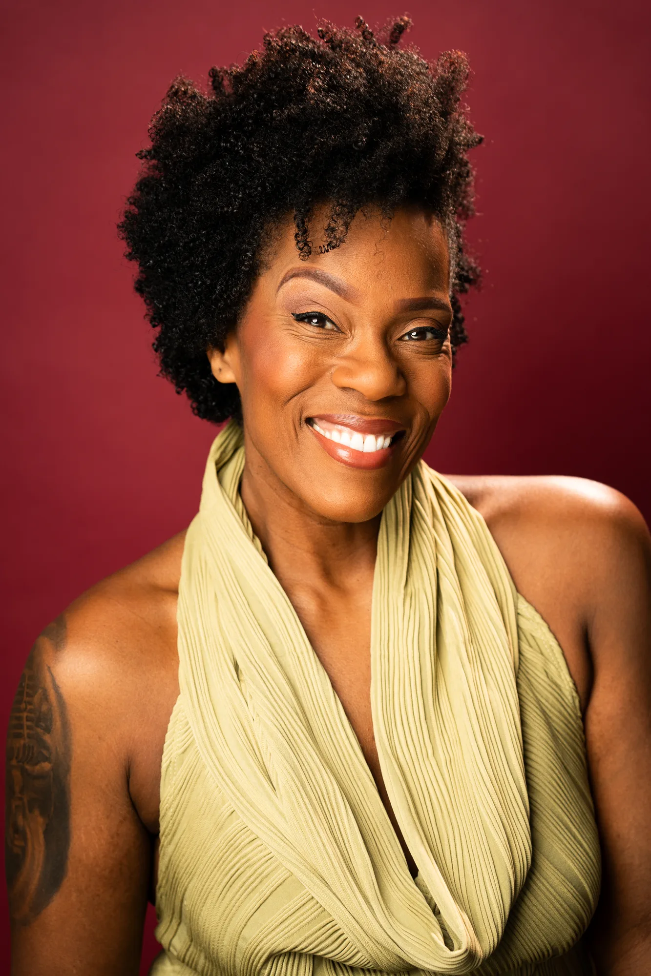 Patrece Bloomfield smiling against a rich red backdrop